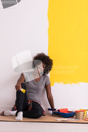 Image of back female painter sitting on floor