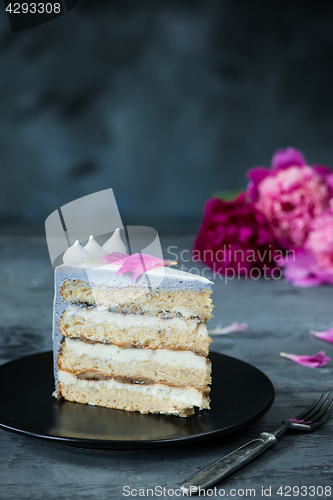 Image of Slice of Birthday Cake with a flowers over a blue background.