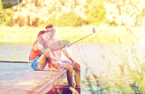 Image of happy teenage couple taking selfie on smartphone