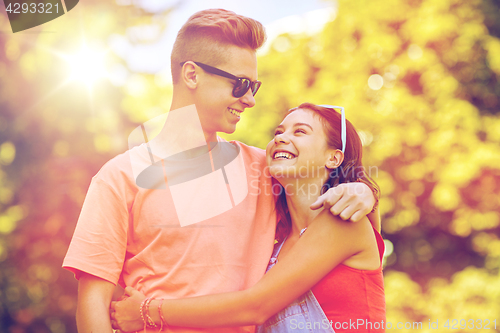 Image of happy teenage couple looking at each other in park