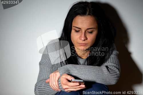 Image of unhappy crying woman with smartphone