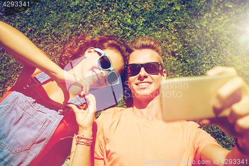 Image of happy couple taking selfie on smartphone at summer