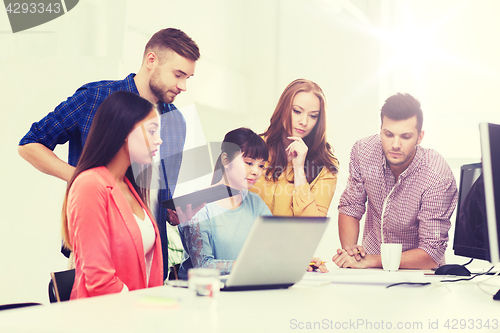 Image of creative team with blueprint working at office