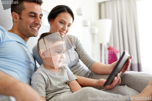 Image of happy family with tablet pc in bed at home