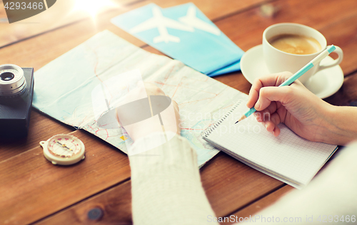 Image of close up of traveler hands with notepad and pencil