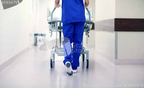 Image of nurse carrying hospital gurney to emergency room