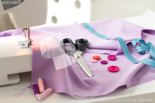 Image of sewing machine, scissors, buttons and fabric