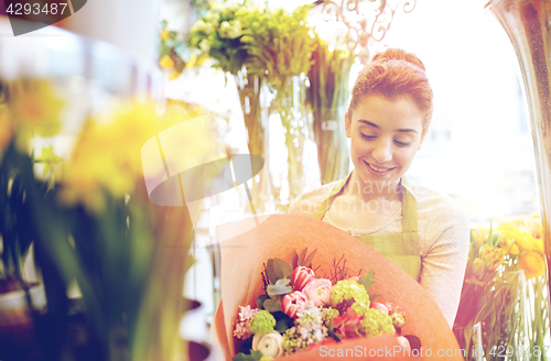 Image of smiling florist woman with bunch at flower shop