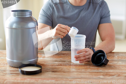 Image of close up of man with protein shake bottle and jar