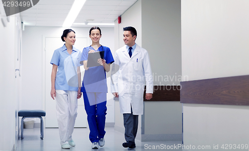 Image of group of smiling medics at hospital with clipboard