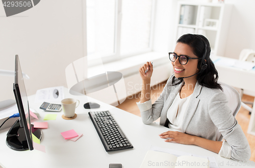 Image of businesswoman with headset and computer at office