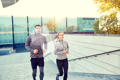 Image of happy couple running upstairs on city stairs