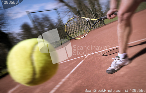 Image of Tennis player stretches to play ball