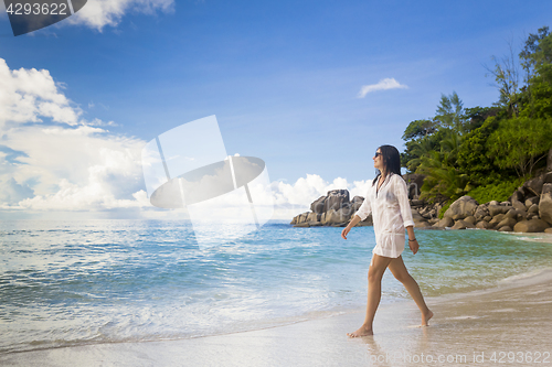 Image of A beautiful woman walking on the beach