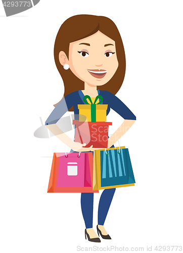 Image of Happy woman holding shopping bags and gift boxes.