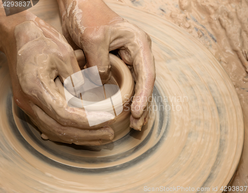 Image of Hands in clay at process of making ceramic on pottery wheel