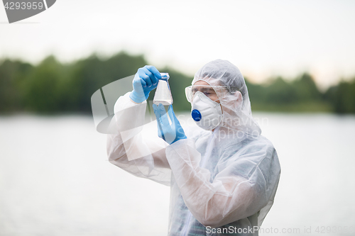 Image of Biologist holds flask with water