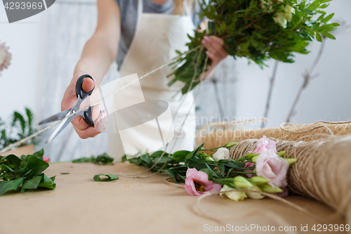 Image of Florist makes bouquet of flowers