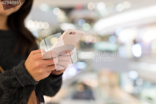 Image of Woman use of mobile phone in shopping mall