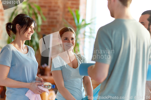 Image of group of people with mats at yoga studio or gym