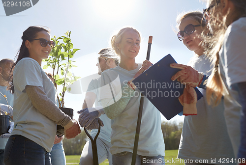 Image of group of volunteers with tree seedlings in park