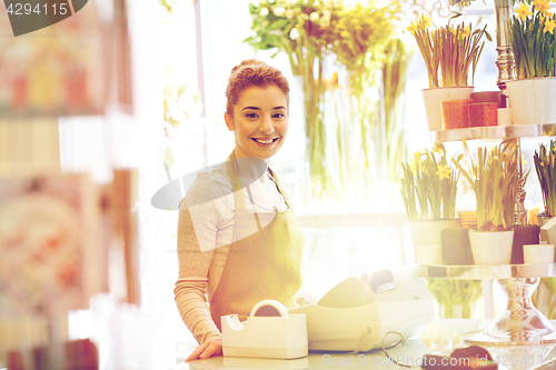 Image of smiling florist woman at flower shop cashbox