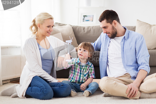 Image of happy family playing with toy wind turbine