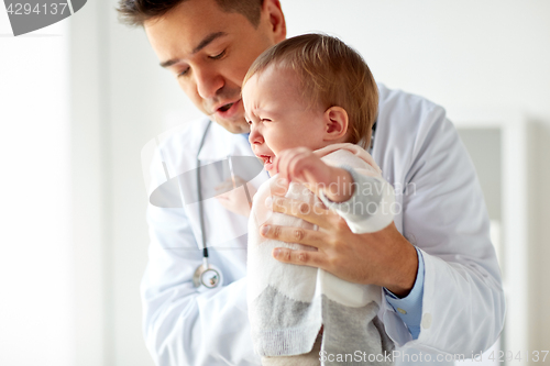 Image of doctor or pediatrician with crying baby at clinic