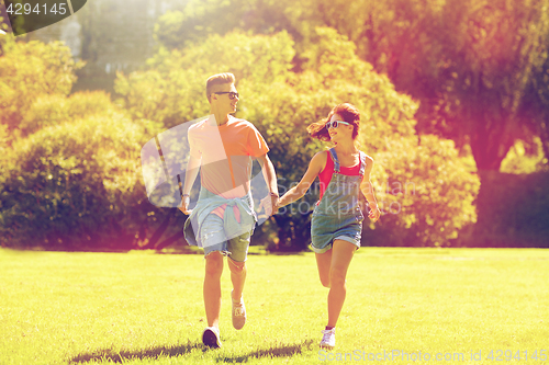 Image of happy teenage couple running at summer park