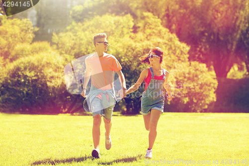 Image of happy teenage couple running at summer park