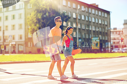 Image of teenage couple with skateboards on city street