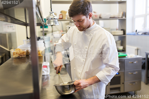 Image of happy male chef cooking food at restaurant kitchen