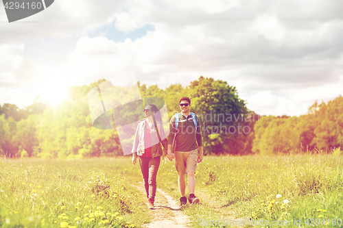 Image of happy couple with backpacks hiking outdoors