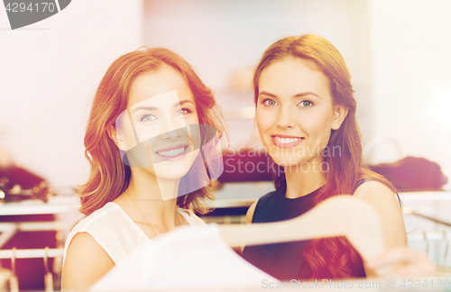 Image of happy women with shopping bags at clothing shop