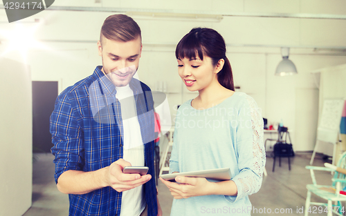 Image of couple with smartphone and tablet pc at office