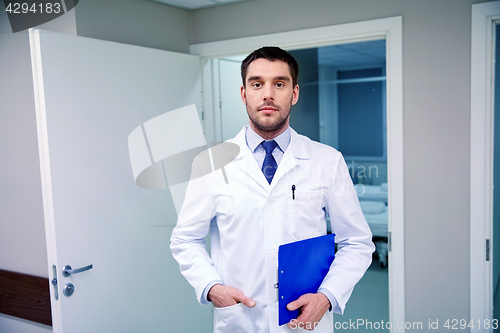 Image of doctor with clipboard at hospital corridor