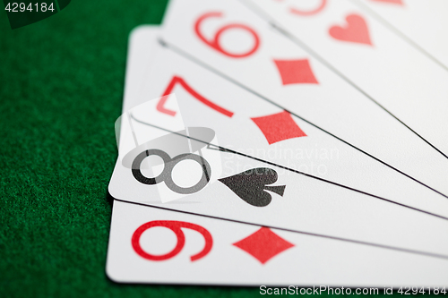 Image of poker hand of playing cards on green casino cloth