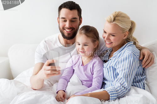 Image of happy family taking selfie by smartphone at home