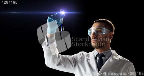 Image of scientist in safety glasses with test tube