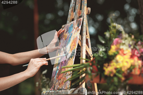 Image of Artist\'s hand close-up on the background of picture