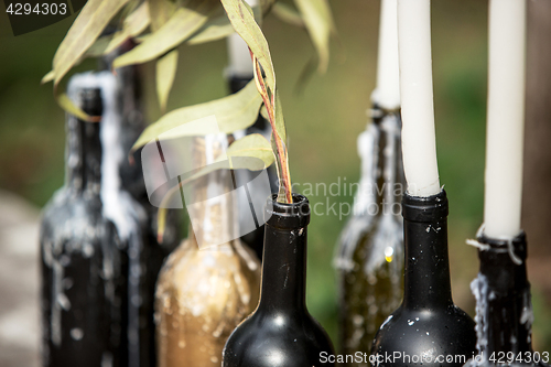 Image of Burning candle in the vintage black bottle