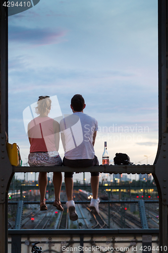 Image of Young couple on romantic date on urban railway bridge, Munich, Germany.