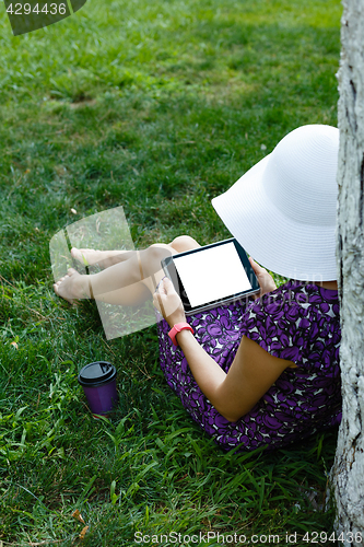 Image of Woman on grass with tablet