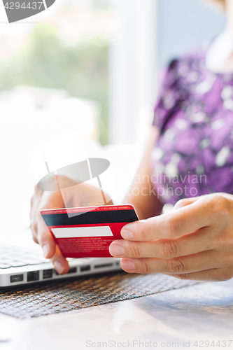 Image of Woman with laptop and credit card in the cafe.