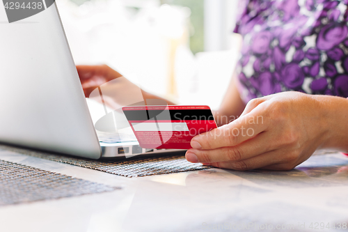 Image of Woman with laptop and credit card in the cafe.