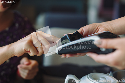 Image of Woman paying his bill in restaurant