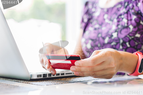 Image of Woman with laptop and credit card in the cafe.