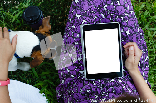 Image of Woman on grass with tablet