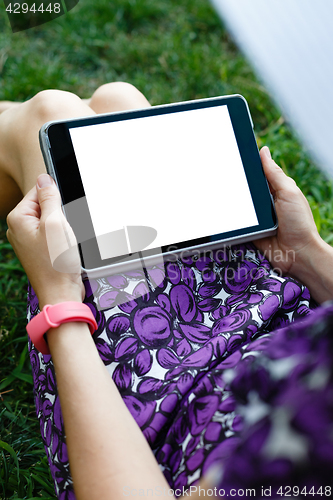 Image of Woman on grass with tablet