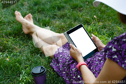 Image of Woman on grass with tablet